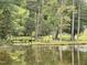 Scenic view of a bridge over a pond, surrounded by mature trees and greenery at 6411 Pondview Ln, Durham, NC 27712
