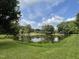 Scenic view of a serene pond surrounded by lush greenery and trees at 6411 Pondview Ln, Durham, NC 27712