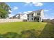 Wide shot of the fenced in backyard, offering a spacious lawn with trees beyond at 6512 Bunker Hill Dr, Raleigh, NC 27610