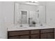 Modern bathroom featuring a double vanity with a large mirror and brown wood cabinets at 6512 Bunker Hill Dr, Raleigh, NC 27610