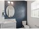 Chic bathroom with an oval mirror, modern fixtures, and stylish wallpaper at 6512 Bunker Hill Dr, Raleigh, NC 27610
