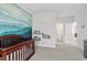 Calming Bedroom with mountain mural, crib, and open doorway to the rest of the home at 6512 Bunker Hill Dr, Raleigh, NC 27610