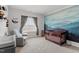 Beautiful Bedroom with blue accent wall, crib, comfortable sitting chair, and plenty of natural light at 6512 Bunker Hill Dr, Raleigh, NC 27610