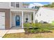 Inviting front porch with a bright blue door and lovely landscaping at 6512 Bunker Hill Dr, Raleigh, NC 27610