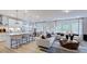 Bright, open-concept living room features a modern kitchen island, dining area, and stylish seating at 668 Morning Glade St, Wake Forest, NC 27587