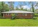 Back exterior of brick home with a lush green lawn at 7 Woodward Way, Chapel Hill, NC 27516