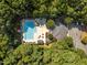 Aerial view of community pool, clubhouse, and parking area nestled among mature trees at 7000 Millstone Ridge Ct, Raleigh, NC 27614