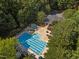 Aerial view of a community pool, clubhouse, and parking lot surrounded by mature trees at 7000 Millstone Ridge Ct, Raleigh, NC 27614