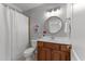 Well-lit bathroom features a single vanity, round mirror, and shower with a white curtain at 7000 Millstone Ridge Ct, Raleigh, NC 27614