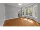 Bright bedroom with hardwood floors, ceiling fan, and large windows at 7000 Millstone Ridge Ct, Raleigh, NC 27614