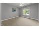 Bedroom with neutral walls, carpet, a painting, and a bright window with views of trees outside at 7000 Millstone Ridge Ct, Raleigh, NC 27614
