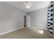 Bedroom with neutral walls, carpet, ceiling fan, and view of an entry hallway and blue stripped curtains at 7000 Millstone Ridge Ct, Raleigh, NC 27614