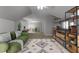 Bonus room featuring a green sofa, entertainment center, ceiling fan, a patterned rug, and neutral walls at 7000 Millstone Ridge Ct, Raleigh, NC 27614
