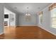 Open dining room with hardwood floors, a chandelier, and an adjacent living space with a fireplace at 7000 Millstone Ridge Ct, Raleigh, NC 27614
