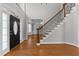 Bright foyer with hardwood floors, a staircase with wrought iron spindles, and a view to the living room at 7000 Millstone Ridge Ct, Raleigh, NC 27614
