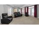 Home theater room with comfortable seating, side tables, and elegant red curtains at 7000 Millstone Ridge Ct, Raleigh, NC 27614