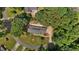 Aerial view of a single-story brick home with solar panels, surrounded by mature trees at 825 Whispering Wind Rd, Burlington, NC 27217
