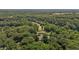 Aerial view of a house surrounded by lush green trees near a golf course at 825 Whispering Wind Rd, Burlington, NC 27217