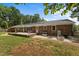 Spacious backyard with a brick patio perfect for entertaining, with mature trees at 825 Whispering Wind Rd, Burlington, NC 27217