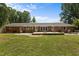 Expansive backyard with a brick patio and lush green lawn surrounded by mature trees at 825 Whispering Wind Rd, Burlington, NC 27217