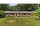 Charming brick home with a manicured lawn, and a vibrant red door at 825 Whispering Wind Rd, Burlington, NC 27217