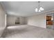 Large living room with neutral carpet, chandelier lighting, and view into kitchen at 825 Whispering Wind Rd, Burlington, NC 27217