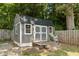 A backyard outbuilding with a wooden fence, surrounded by natural landscaping at 825 Whispering Wind Rd, Burlington, NC 27217