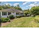 Well-maintained single-story home with green shutters, lush lawn and manicured landscaping at 877 Millcroft, Pittsboro, NC 27312