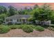 Charming single-story home with black shutters, wrought iron fence and lush landscaping at 877 Millcroft, Pittsboro, NC 27312