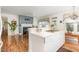 Open kitchen with island and adjacent dining area, featuring a fireplace and hardwood floors at 877 Millcroft, Pittsboro, NC 27312