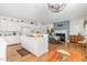 Open kitchen with island and adjacent dining area, featuring a fireplace and hardwood floors at 877 Millcroft, Pittsboro, NC 27312