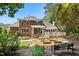 Brick home back exterior featuring a deck, patio, and beautifully landscaped backyard garden at 103 Saint Brides Ct, Cary, NC 27518