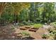 This backyard has a swing set, seating, garden beds, and lush greenery at 103 Saint Brides Ct, Cary, NC 27518
