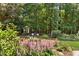 This backyard has a swing set, seating, and a large garden with pretty pink flowers at 103 Saint Brides Ct, Cary, NC 27518