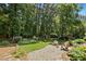 Serene backyard featuring a patio, seating area, lush greenery, and mature trees at 103 Saint Brides Ct, Cary, NC 27518
