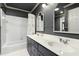 Traditional bathroom with gray walls, double sinks, stylish mirrors, and shower-tub combination at 103 Saint Brides Ct, Cary, NC 27518