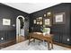 Stylish office with dark accent wall, hardwood floors, and door to small butler's pantry at 103 Saint Brides Ct, Cary, NC 27518