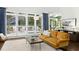 Bright living room with hardwood floors, yellow sofa, and large windows showcasing deck at 103 Saint Brides Ct, Cary, NC 27518