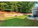 Back yard features tiered retaining wall and a patio with an outdoor seating area at 10809 Grassy Creek Pl, Raleigh, NC 27614
