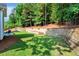 Backyard view features a tiered retaining wall and outdoor seating area with patio at 10809 Grassy Creek Pl, Raleigh, NC 27614