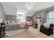 Comfortable bedroom with gray walls, a plush bed, a cozy sitting area, and natural light at 10809 Grassy Creek Pl, Raleigh, NC 27614