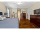Well-lit bedroom features hardwood floors and a glimpse into an en-suite bathroom at 10809 Grassy Creek Pl, Raleigh, NC 27614