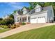Home with front porch, two-car garage, manicured lawn, and flowering landscaping at 10809 Grassy Creek Pl, Raleigh, NC 27614