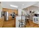 Open kitchen area with stainless appliances, light wood cabinets, bar seating, and view of the living area at 10809 Grassy Creek Pl, Raleigh, NC 27614