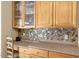 Close-up of the kitchen details featuring light wood cabinets, drawers and a mosaic backsplash at 10809 Grassy Creek Pl, Raleigh, NC 27614