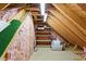 Unfinished attic provides ample storage with wood framing, pink insulation, and an overhead light fixture at 1084 Wild Briar Ln, Stem, NC 27581