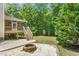 The backyard features a screened-in porch, a deck, a fire pit, lush greenery and stairs to the backyard at 1084 Wild Briar Ln, Stem, NC 27581