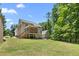 Expansive backyard features a screened-in porch, lush trees, and a manicured lawn at 1084 Wild Briar Ln, Stem, NC 27581