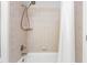 A tiled shower/bath features an adjustable shower head with a neutral-colored, tiled surround and shower curtain at 1084 Wild Briar Ln, Stem, NC 27581