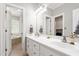 Bright bathroom with double sinks, modern fixtures, and doorway view of bathtub/shower combo at 1084 Wild Briar Ln, Stem, NC 27581